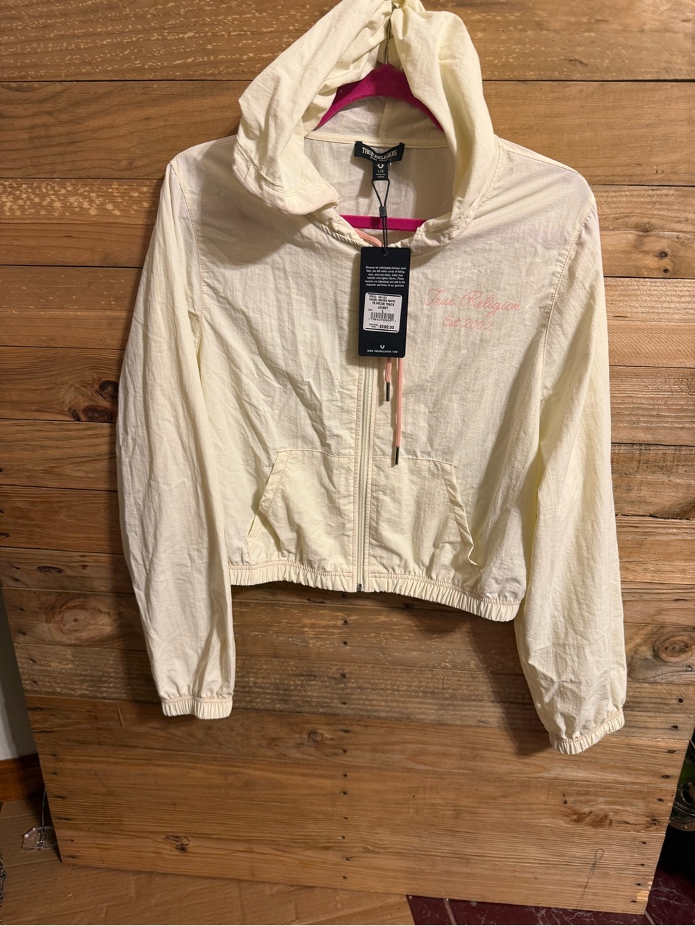 True Religion cream nylon track windbreaker jacket featuring a hooded full-zip